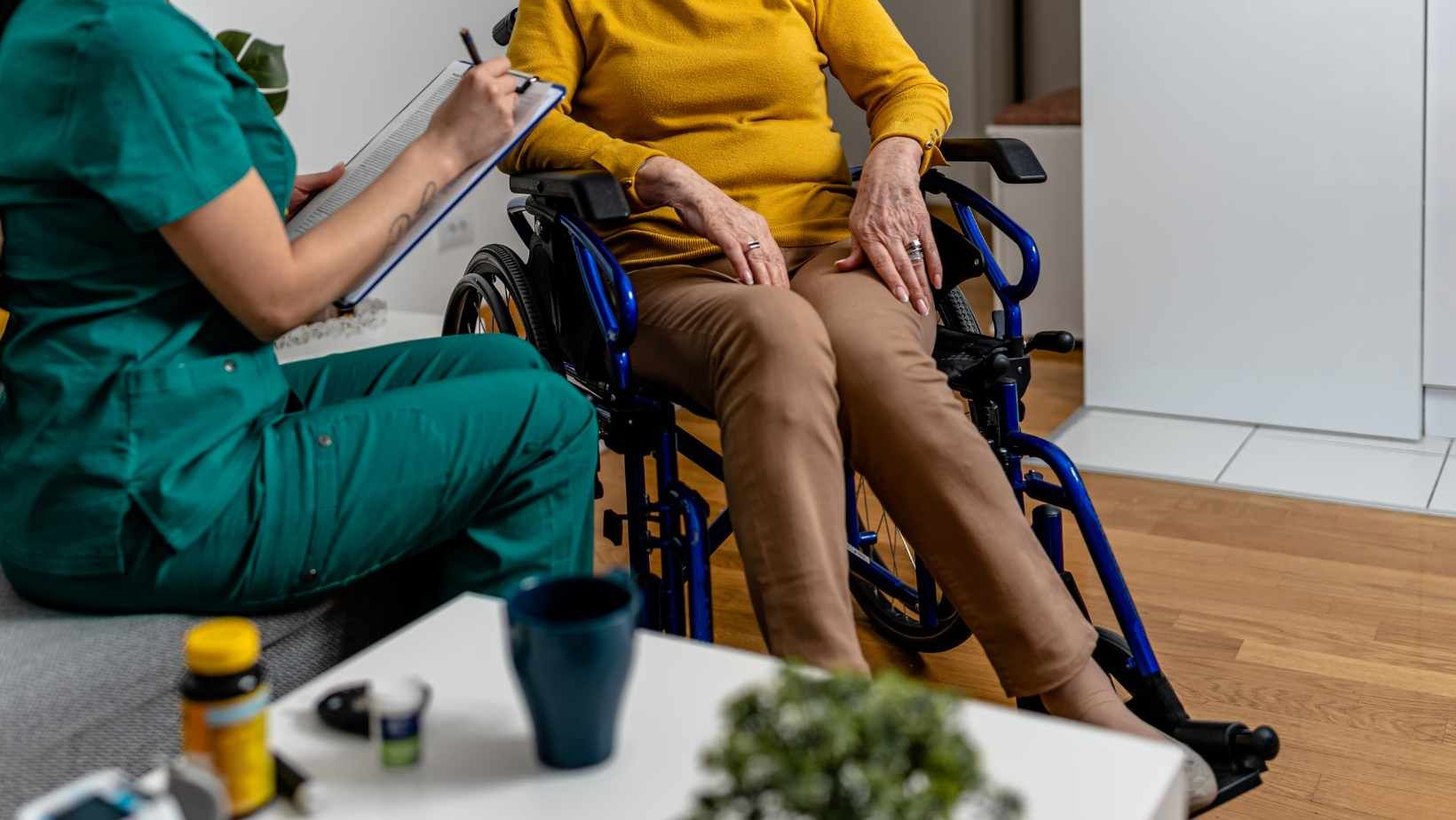 Shot of caregiver speaking to woman in wheelchari