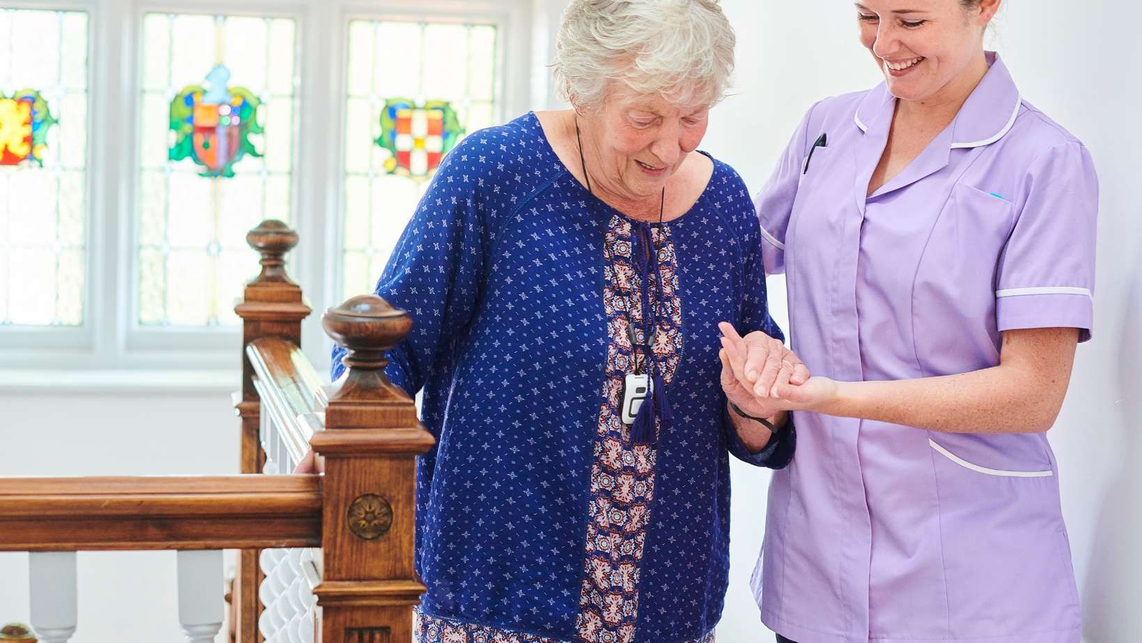 Woman being helped up the stairs by caregiver