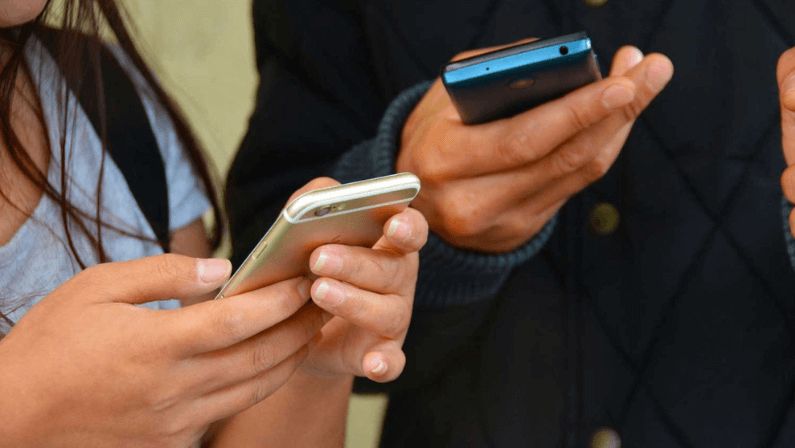 Two persons scrolling their phones searching for a user friendly virtual platform